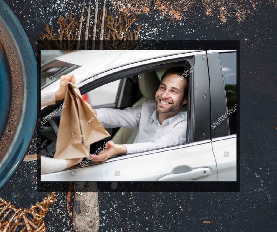 Man in a car picking up his take out dinner bags