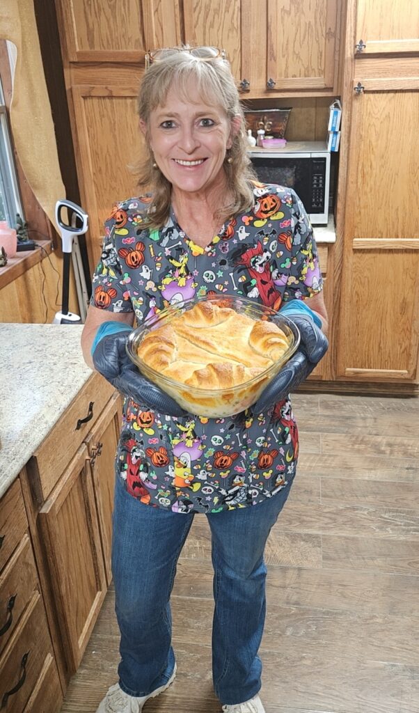 Lisa holding a golden-baked Chicken Pot Pie in Voilà Glass Bakeware — an eco-friendly, reusable time saver for Cajun comfort meals.