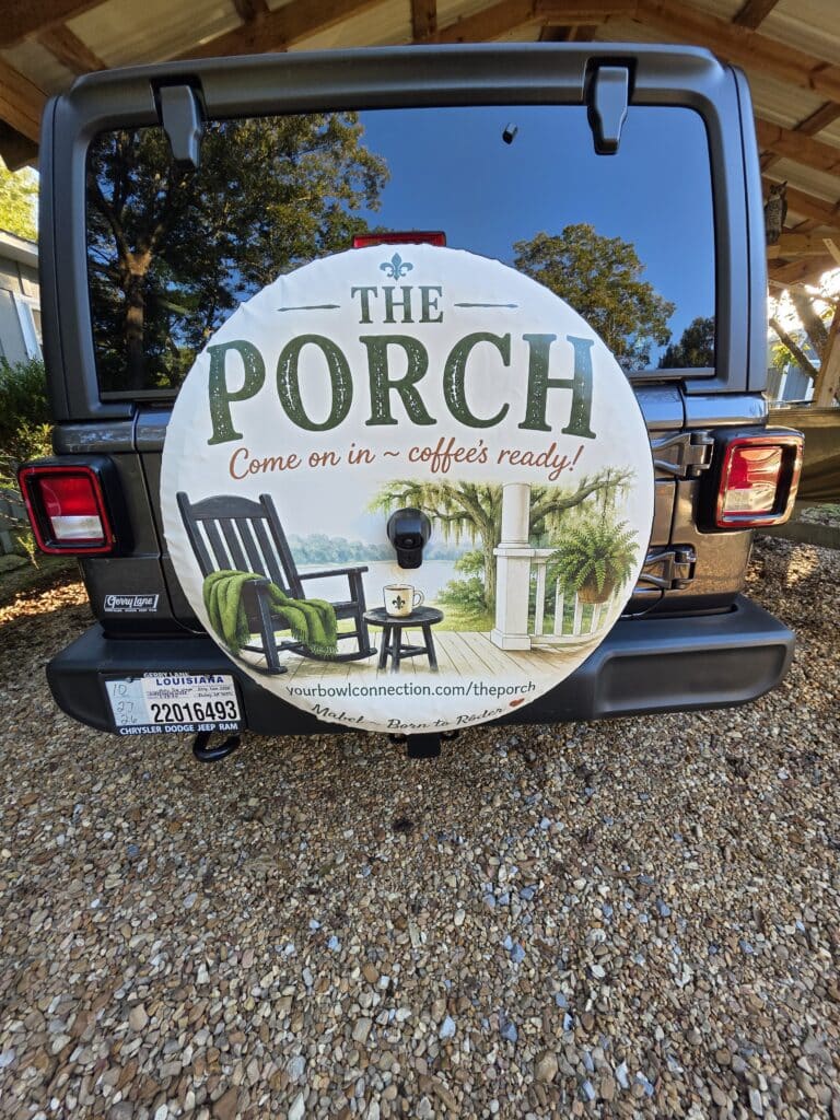 The Porch spare tire cover on Mabel the Jeep with the backup camera extending through a small opening cut into the cover.